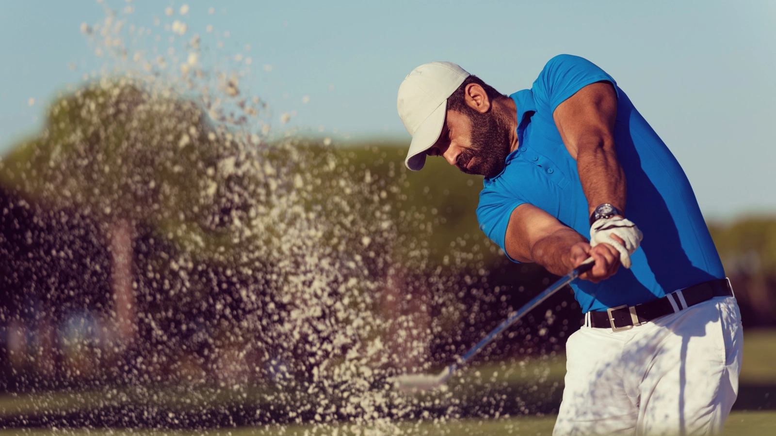 A golfer playing out of a bunker